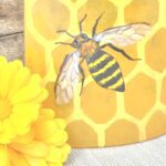 Close up of short fused glass bee panel with flowers