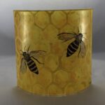 Fused glass panel with handpainted bees on honeycomb background